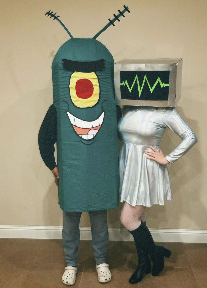 Two people in creative Halloween costumes, one as a robot and the other as a cartoonish alien character.