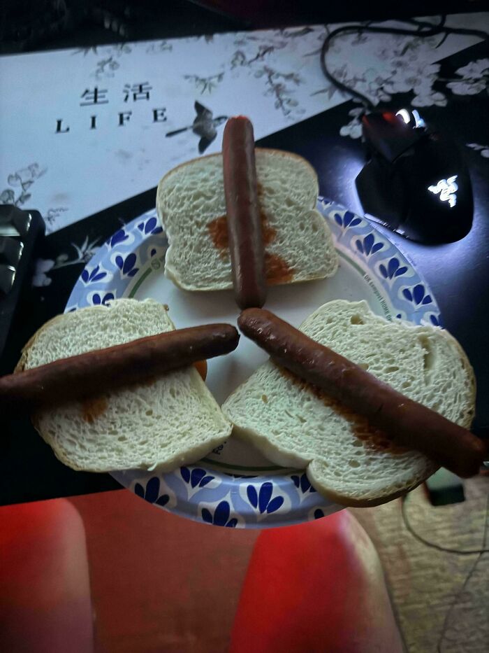 Three hot dogs awkwardly placed on plain white bread slices on a plate, illustrating unholy food pics.