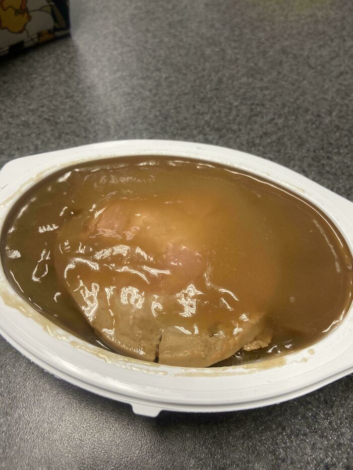 Unholy food pic of a brown gelatinous substance in a white plastic dish that looks unappetizing on a countertop