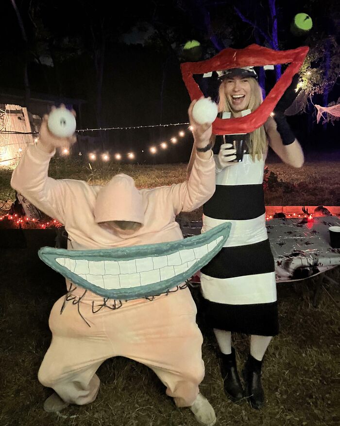 Two people wearing creative Halloween costume ideas; one in an exaggerated face suit and the other in a striped dress with a large mouth frame.