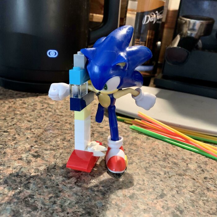 Blue Sonic figure interacting with a colorful LEGO invention on a kitchen countertop showcasing kids' creativity.