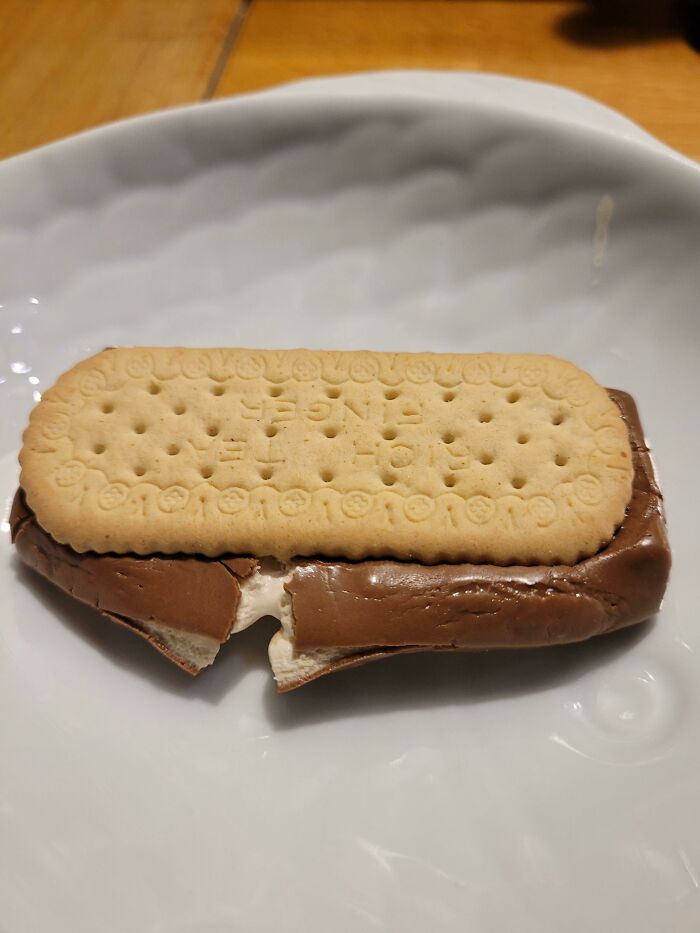 Biscuit placed on top of a melted chocolate and marshmallow treat, showcasing a simple kids invention surprise.