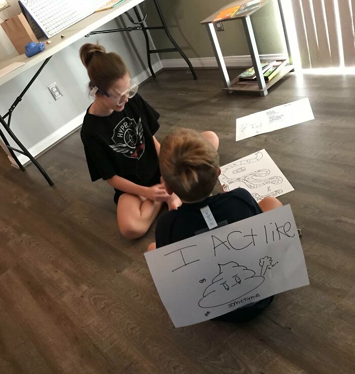 Two kids sitting on the floor with invention drawings, showcasing creativity and surprising parents with new inventions.