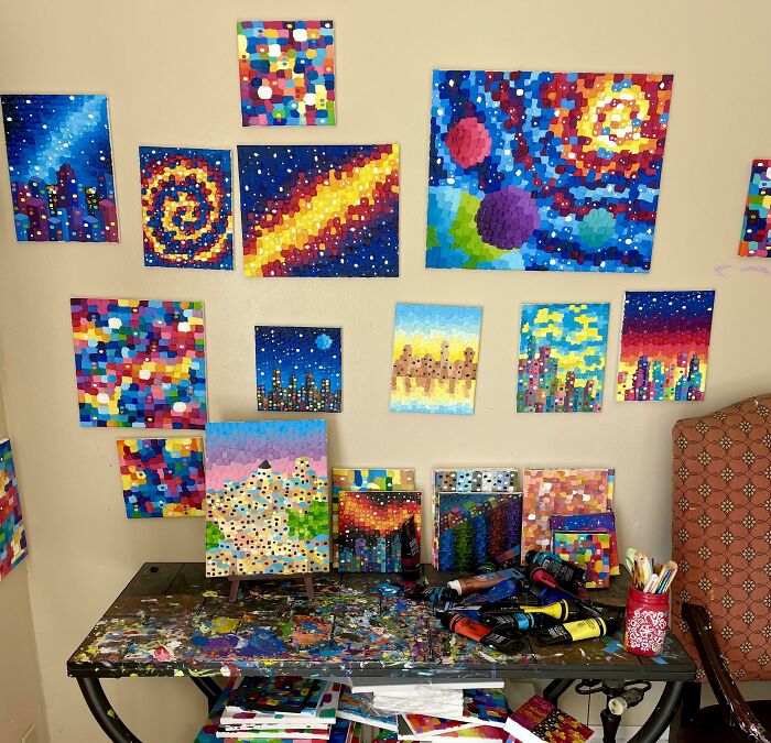 Colorful abstract paintings in a home studio showcasing simple living and creativity with minimalistic art supplies and decor.