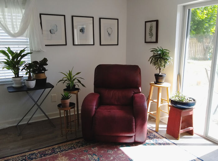 Cozy living space with simple living decor, a comfortable chair, indoor plants, and natural light from sliding glass doors.