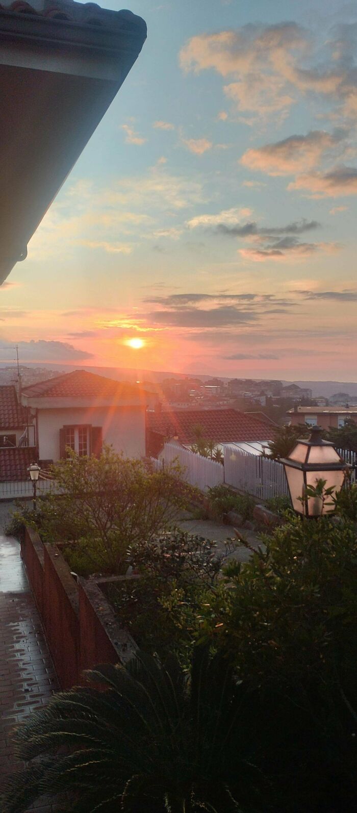 Sunset over a quiet residential area with plants and rooftops, reflecting the calmness of simple living lifestyle.