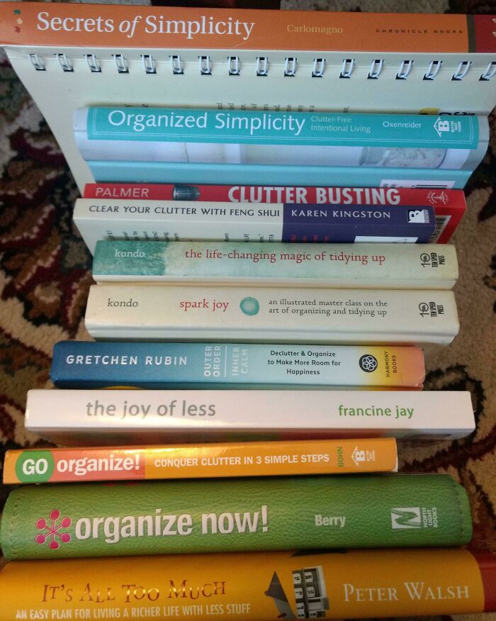 Stack of books about simple living, clutter busting, and organizing for appreciating having less and intentional living.