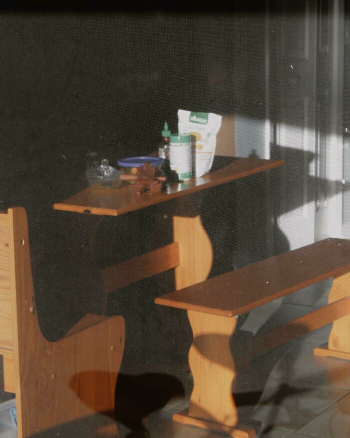 Sunlit simple living wooden bench and table with a few everyday items, showcasing minimal and intentional lifestyle.