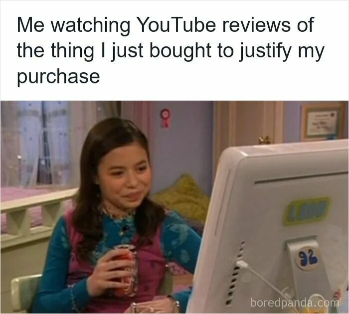 Young woman watching YouTube reviews on computer, illustrating specific moments in our lives that aren’t original experiences.