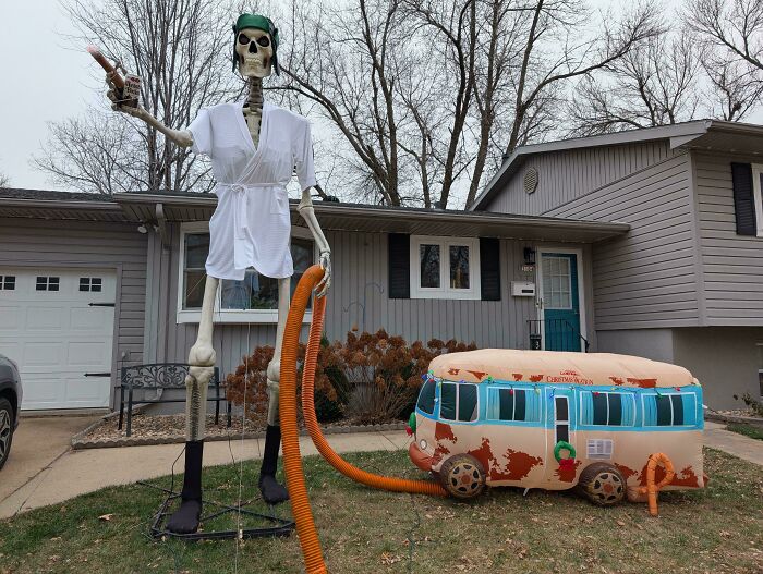 Giant skeleton in golf outfit and inflatable Halloween decorations displayed as outdoor Halloween decorations on a lawn.