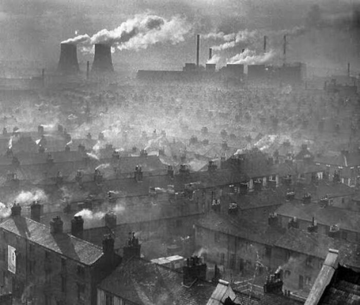 Industrial area with heavy smoke pollution over rooftops, illustrating fascinating photos and facts on environmental impact.