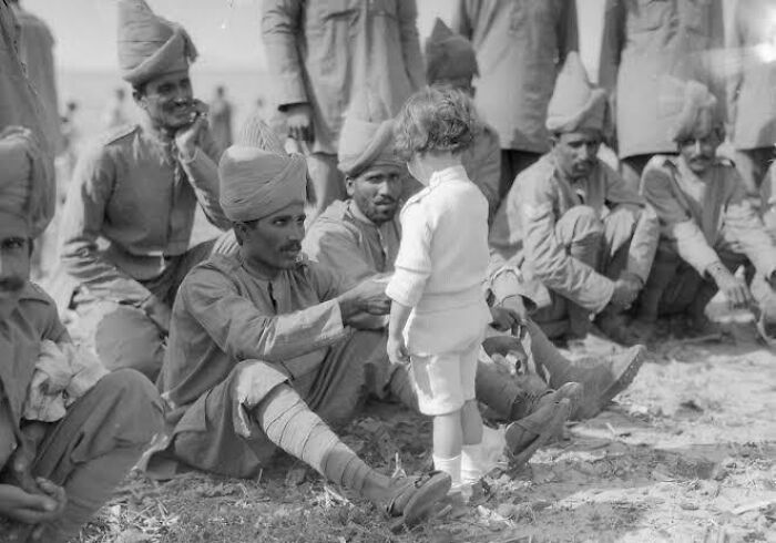 Soldiers in traditional uniforms interact warmly with a young child, showcasing fascinating photos that help see the world differently.