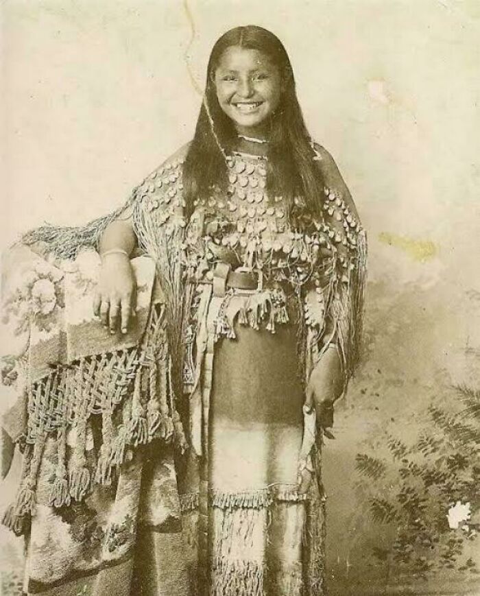 Vintage photo of a smiling Native American woman in traditional attire, part of fascinating photos that change perspectives.