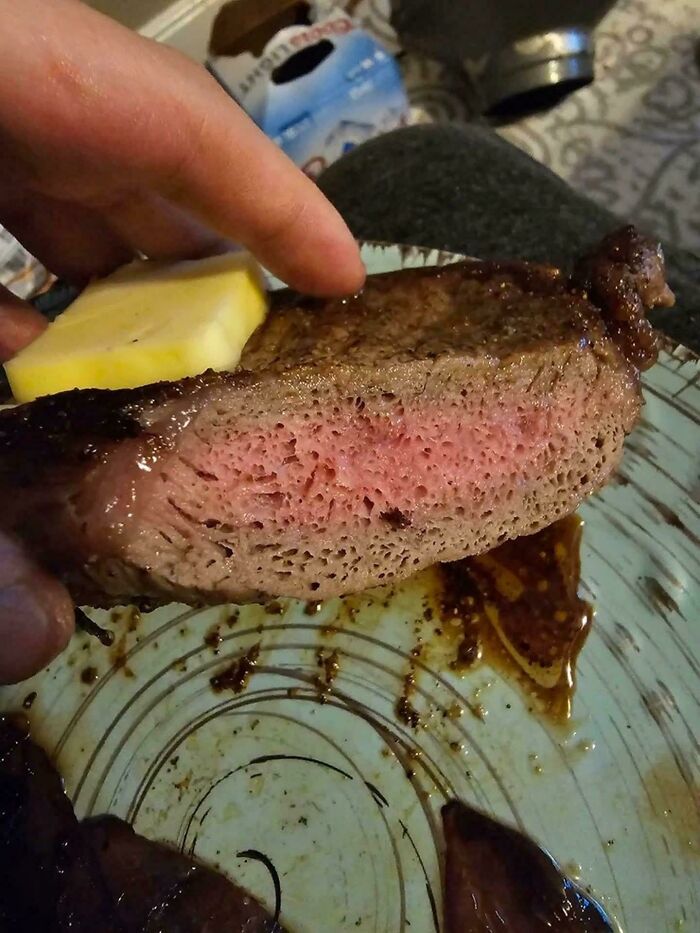 Close-up of a cooked steak showing porous texture that can trigger trypophobia reactions in sensitive viewers.