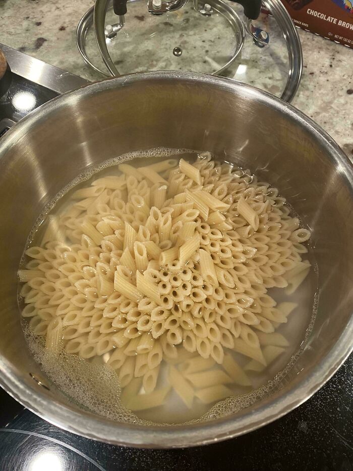 Pasta in boiling water forming clustered holes, a harmless-looking image that triggers trypophobia reactions.