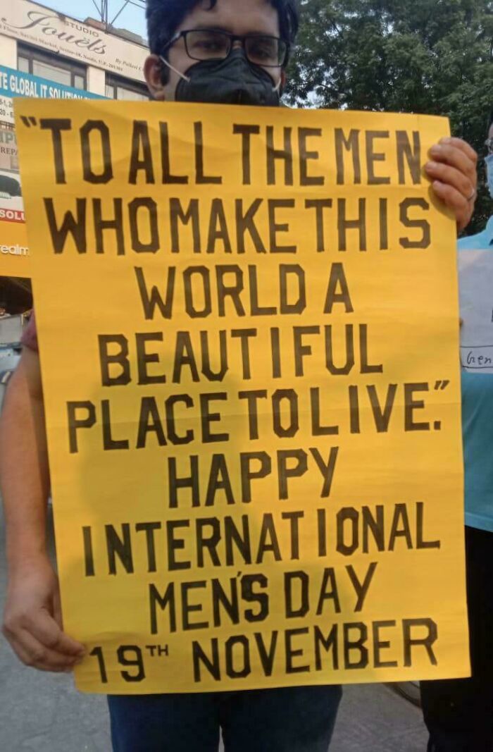 Person holding a sign celebrating men and their positive impact for International Men’s Day on 19th November.
