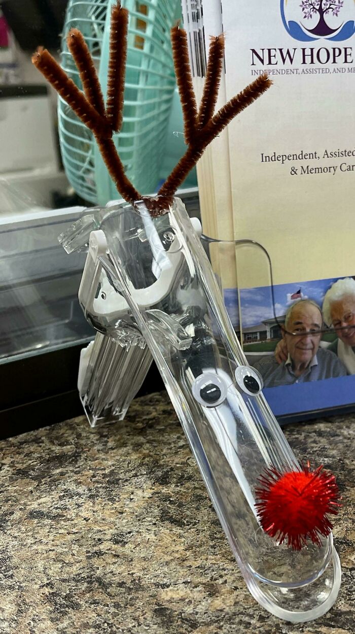 Clear plastic clip decorated as a reindeer with pipe cleaner antlers and a red pom-pom nose in a doctor's office.
