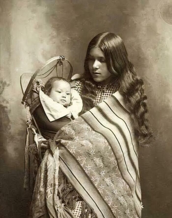 Vintage sepia photo of a young woman holding a baby, one of 80 fascinating photos that may change how you see the world