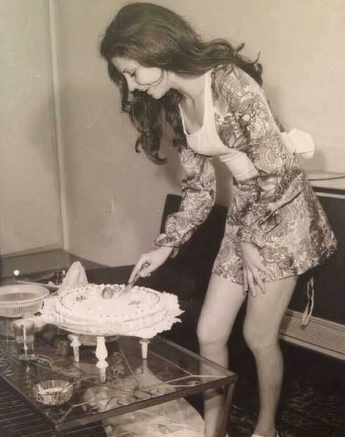 Vintage photo of a woman cutting a cake, showcasing fascinating moments captured in photos that inspire new perspectives.