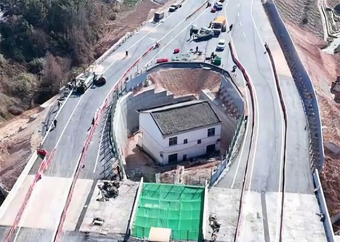A fascinating photo showing a house preserved inside a circular road under construction, highlighting unique world views.