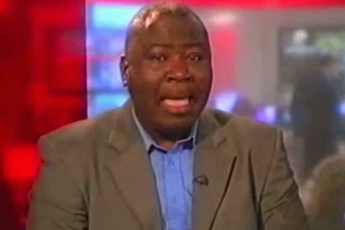 Man in a gray suit and blue shirt speaking on a news broadcast, illustrating fascinating photos and stories.