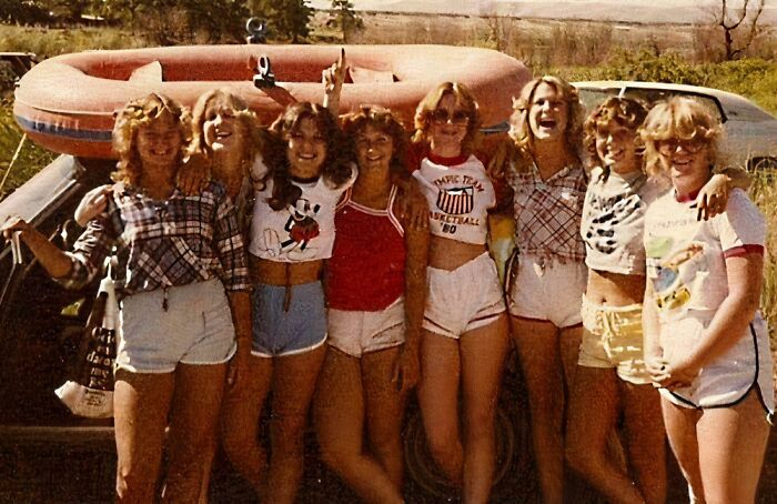 Group of friends posing outdoors in summer clothes for a vacation picture from a time before cell phone cameras.