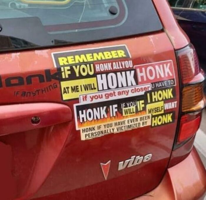 Red Pontiac Vibe with clever and hilarious bumper stickers about honking etiquette snapped on the road.