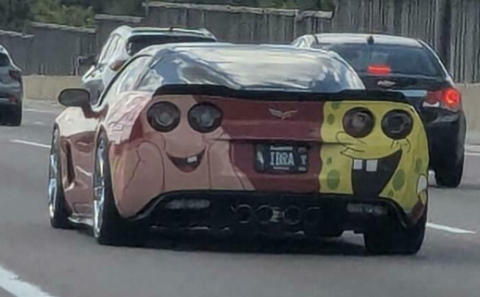 Car with a weird and funny SpongeBob-themed painted rear seen on a busy highway, fitting the blessed and cursed pics keyword.