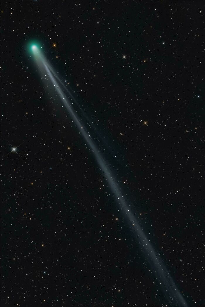 Bright green comet with a long glowing tail streaking across a starry night sky in epic astronomy photos.