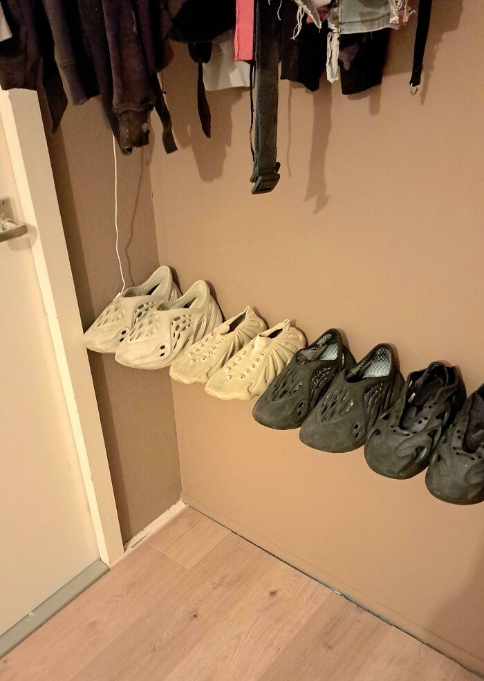 Unphotoshopped photo showing shoes hanging on the wall in a row, creating a surreal but real visual effect.