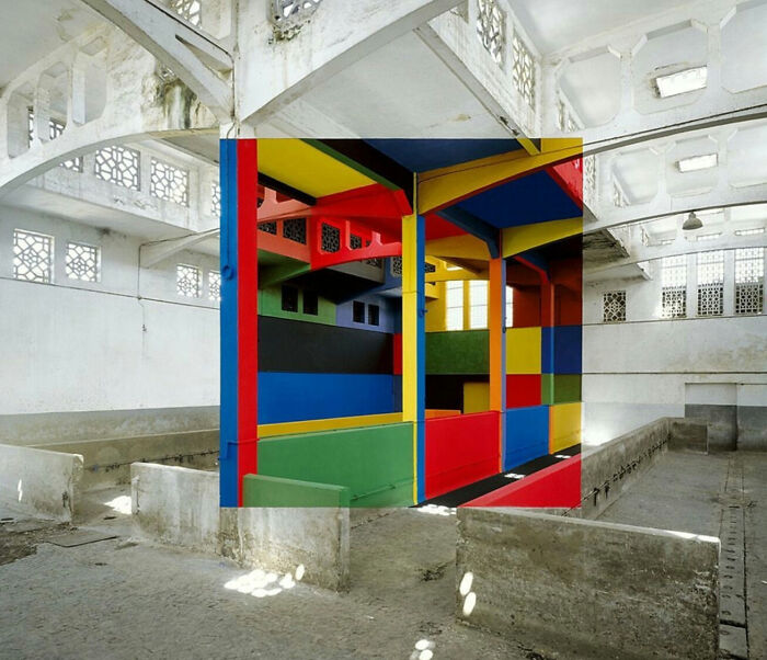 Colorful geometric mural painted on interior columns of an old industrial building in unphotoshopped real photo.