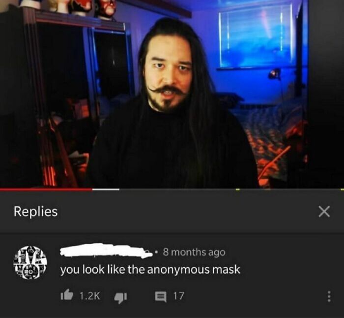 Man with long hair and mustache in a dark room with visible YouTube comments showing hilarious statements.