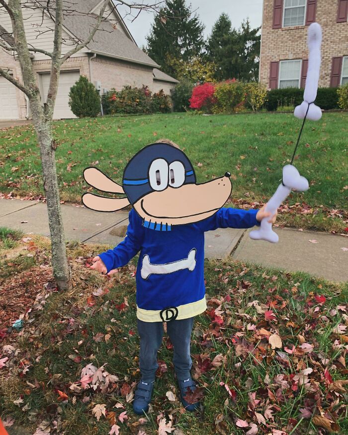 Child wearing a creative dog costume holding a toy bone outside, showcasing kids Halloween costume ideas that worked like magic