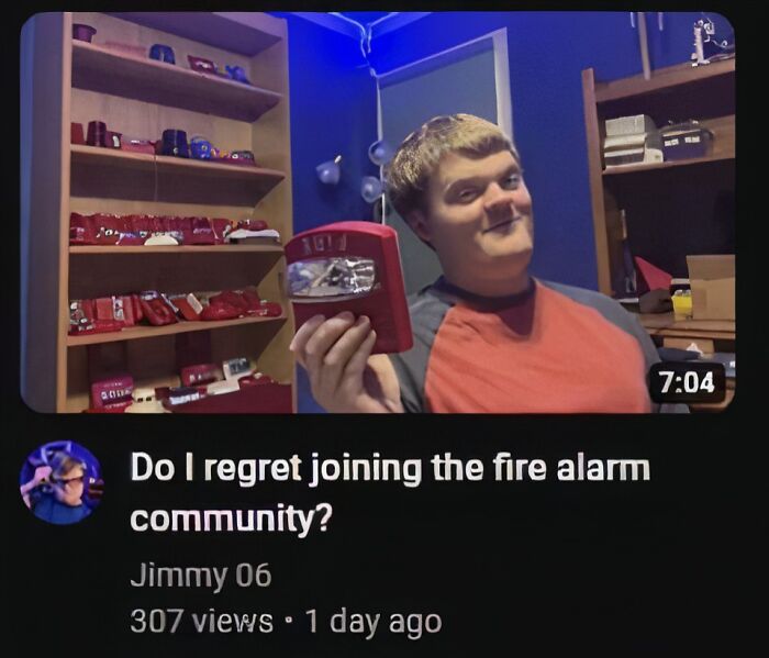 Person holding a fire alarm device in a room with shelves, reflecting playful pleasures of the occult context.
