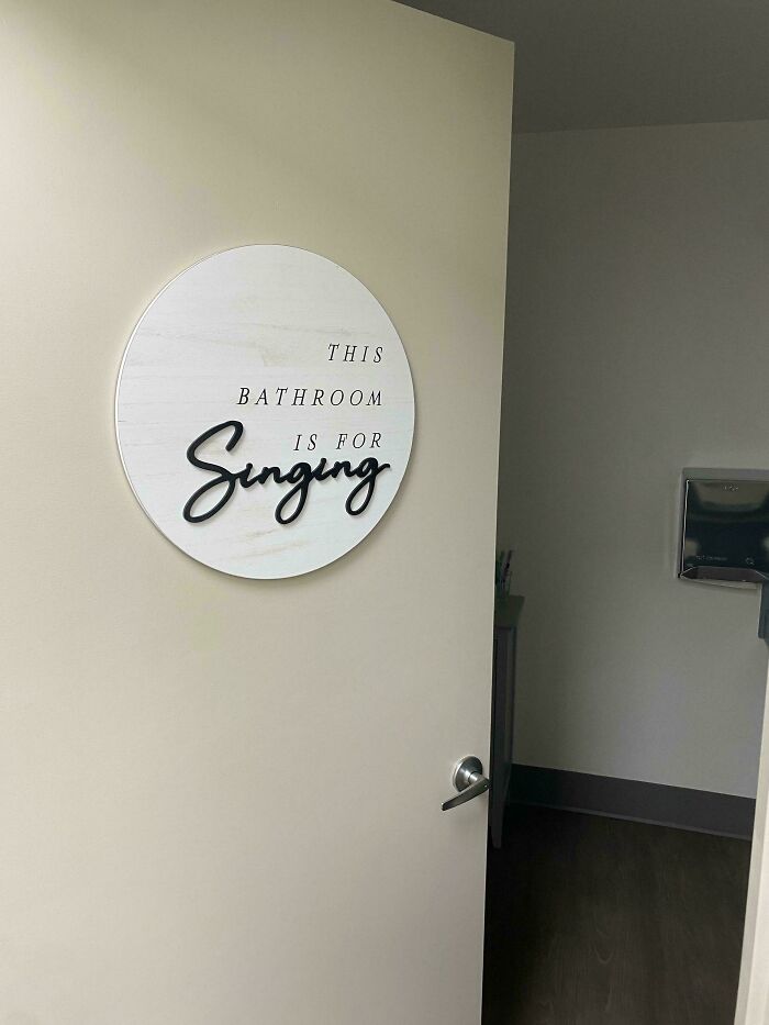 Bathroom door at a doctor's office with a humorous sign saying it is for singing to put patients at ease.