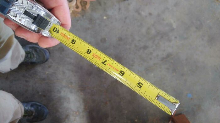 Person holding a tape measure showing a length on the floor, illustrating careless online shopping backfired measurement.