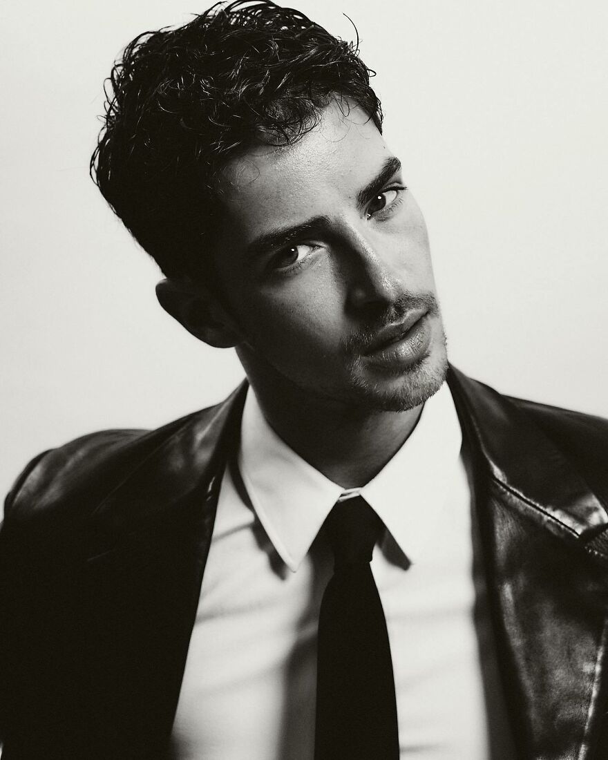 Black and white portrait of a stylish Manu Ríos with curly hair and leather jacket representing most handsome man in the world 2025.