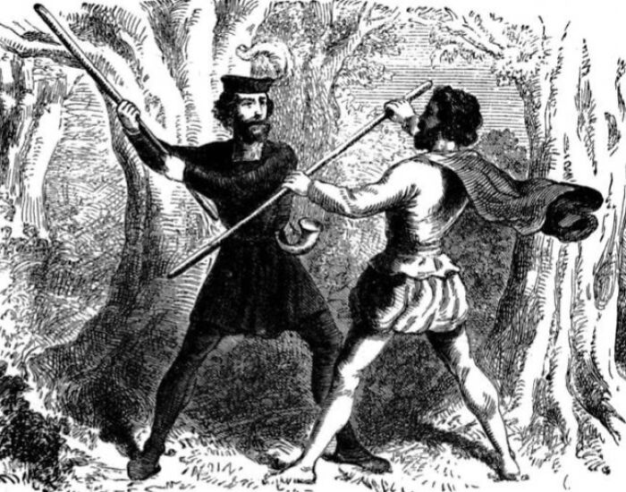 Two men dressed in historical clothing engaged in a dangerous and unsafe sport involving wooden sticks in a forest setting.