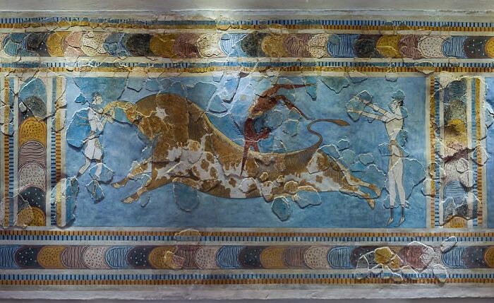 Ancient fresco depicting a dangerous and unsafe historical bull-leaping sport with acrobats and a bull.
