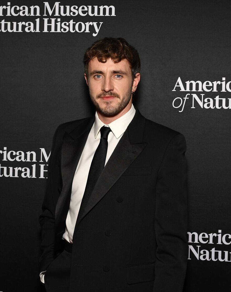 Paul Mescal in black suit and tie posing at American Museum event, representing most handsome man in the world 2025.