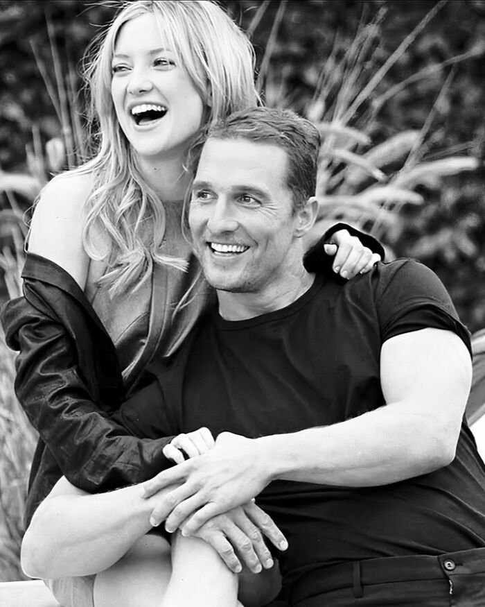 Black and white photo of a joyful couple smiling outdoors, representing people who left a mark in movie and music industries.