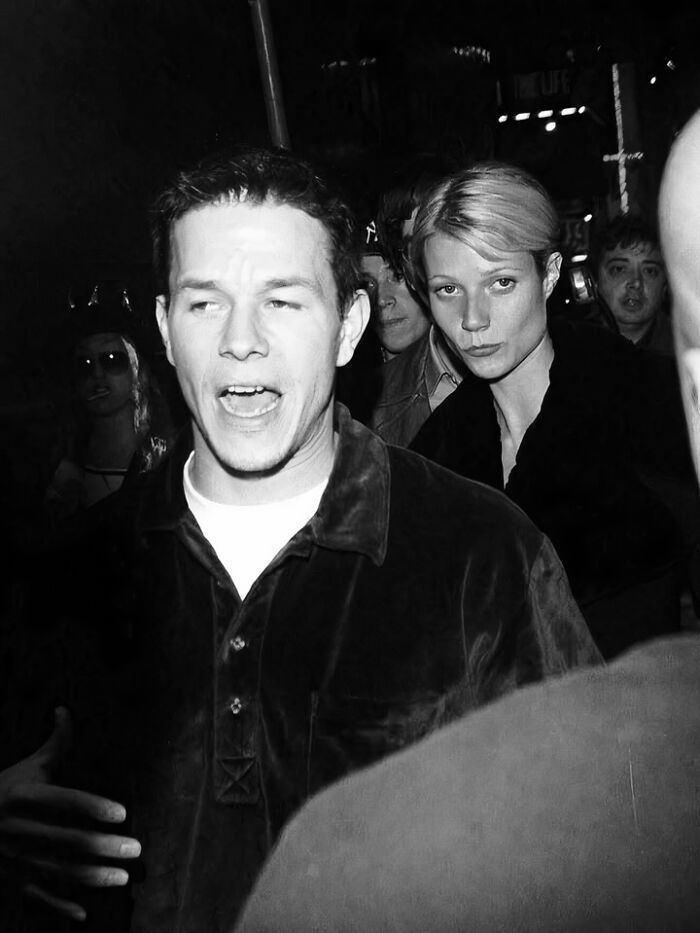 Black and white photo of two people who left a mark in the movie and music industries at a crowded event.