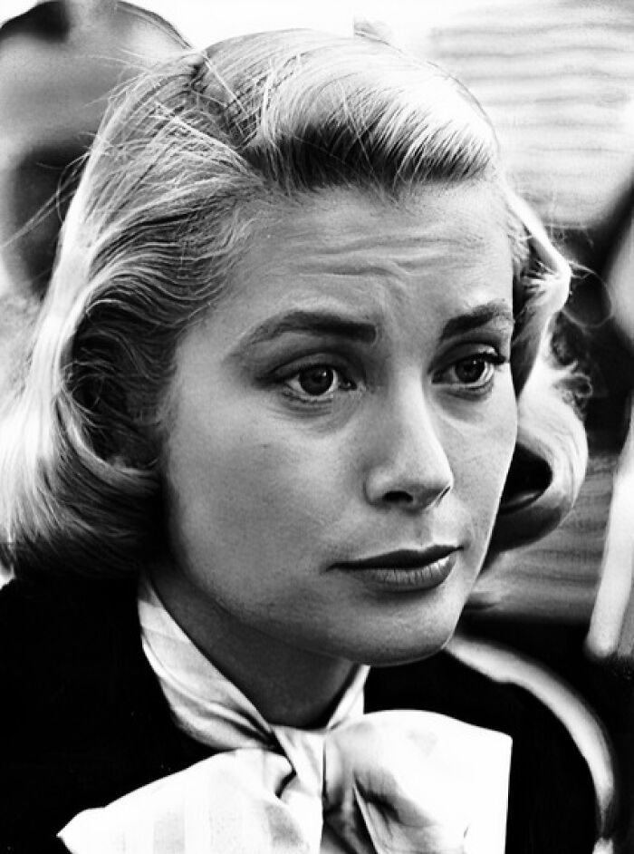 Black and white close-up of a woman with vintage hairstyle, representing iconic people in movie and music industries.