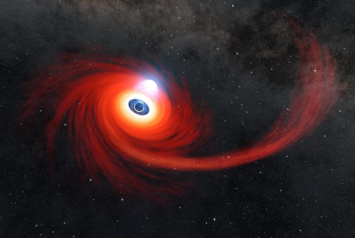Red swirling cosmic formation around a black hole showcasing epic astronomy photos of the beauty and mystery of space.