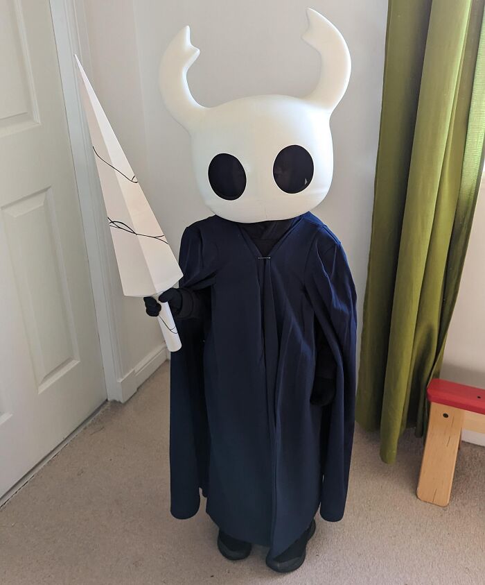 Child dressed in a creative Halloween costume holding a large white paper weapon, showcasing kids Halloween costume ideas.