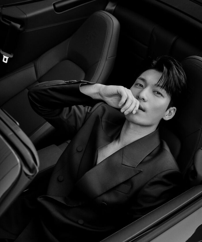 Young man posing confidently in car seat wearing a stylish suit, representing handsome man 2025.