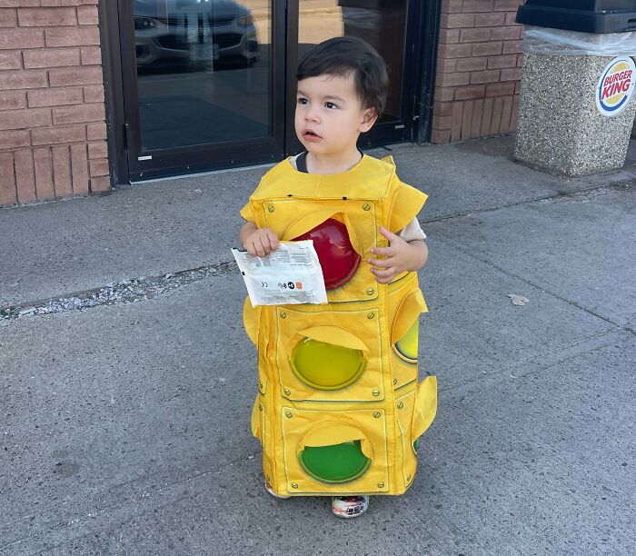 Toddler wearing a creative traffic light costume outdoors, one of the amazing kids Halloween costume ideas that worked like magic.