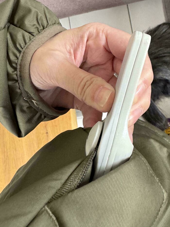 Hand holding small oversized shoe slipping into a pocket, illustrating careless online shopping backfired in a funny way.