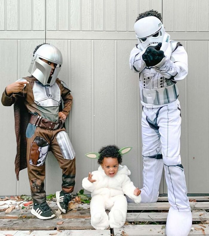 Three kids in amazing kids Halloween costume ideas including Star Wars themed outfits posing outdoors on wooden pallets.