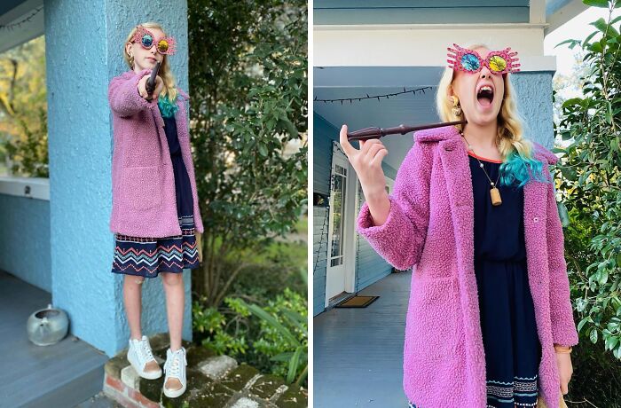 Child in creative kids Halloween costume with colorful glasses and pink coat holding a magic wand outdoors